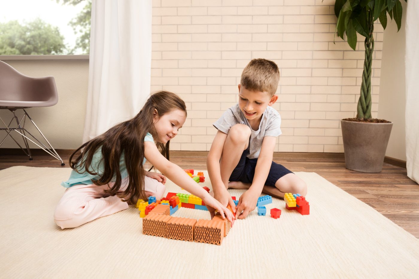 Children playing with miniature bricks and plastic building blocks