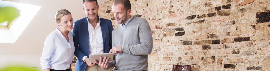 Architect with tablet presenting tablet to end customer at studio in attic loft