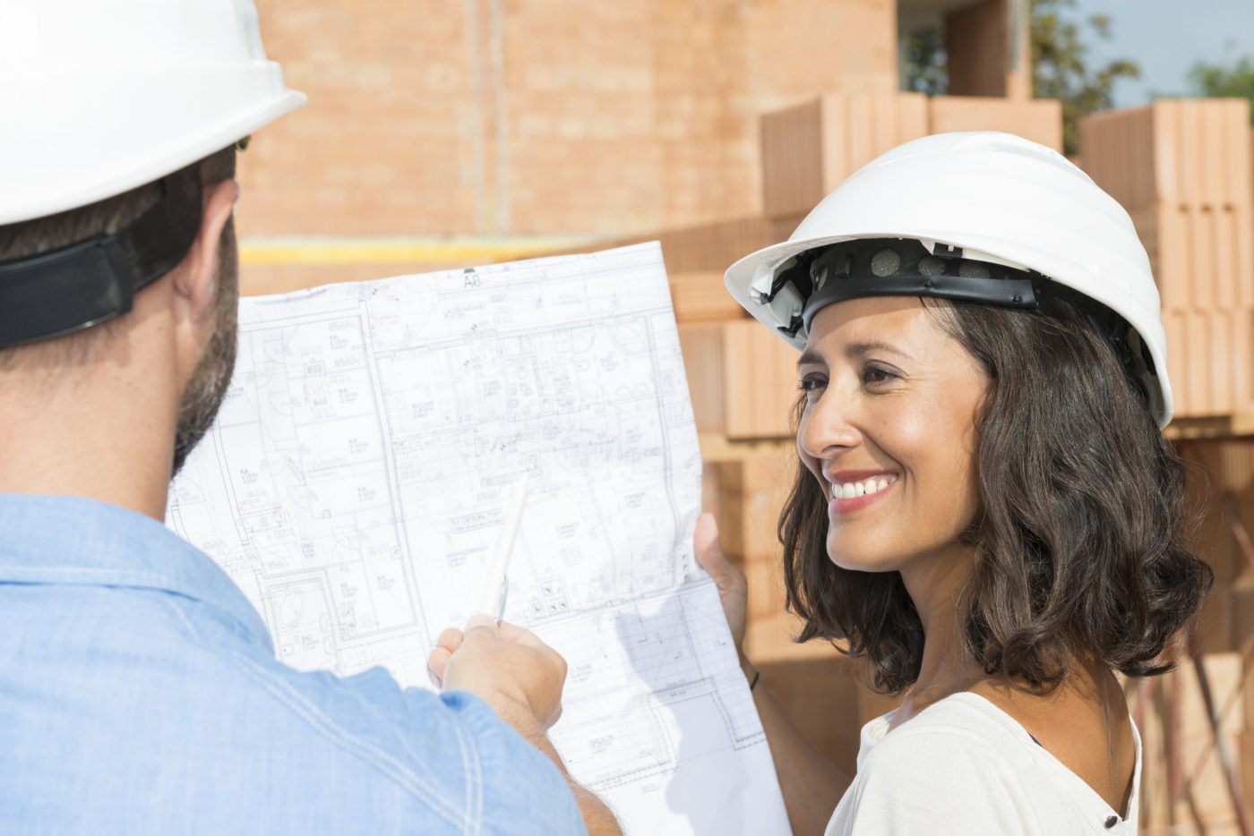 Man with pen pointing at architectural drawing
