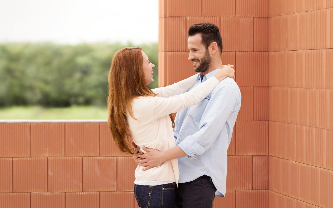 Man and woman celebrating their future home inside building shell