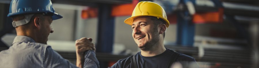 Happy metal worker greeting his manager in aluminum mill.