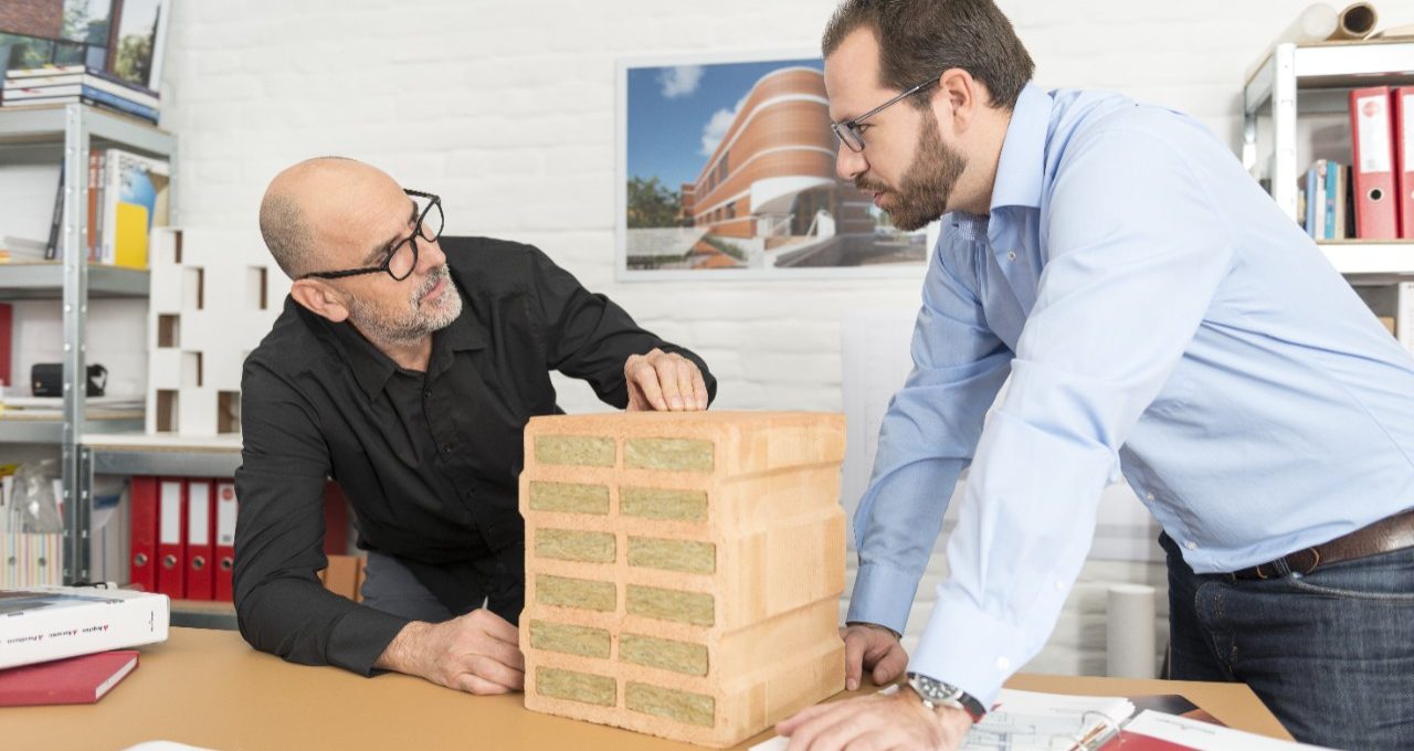 Architect and Wienerberger project manager talking about advantages of a mineral wool infilled clay block at architect's office