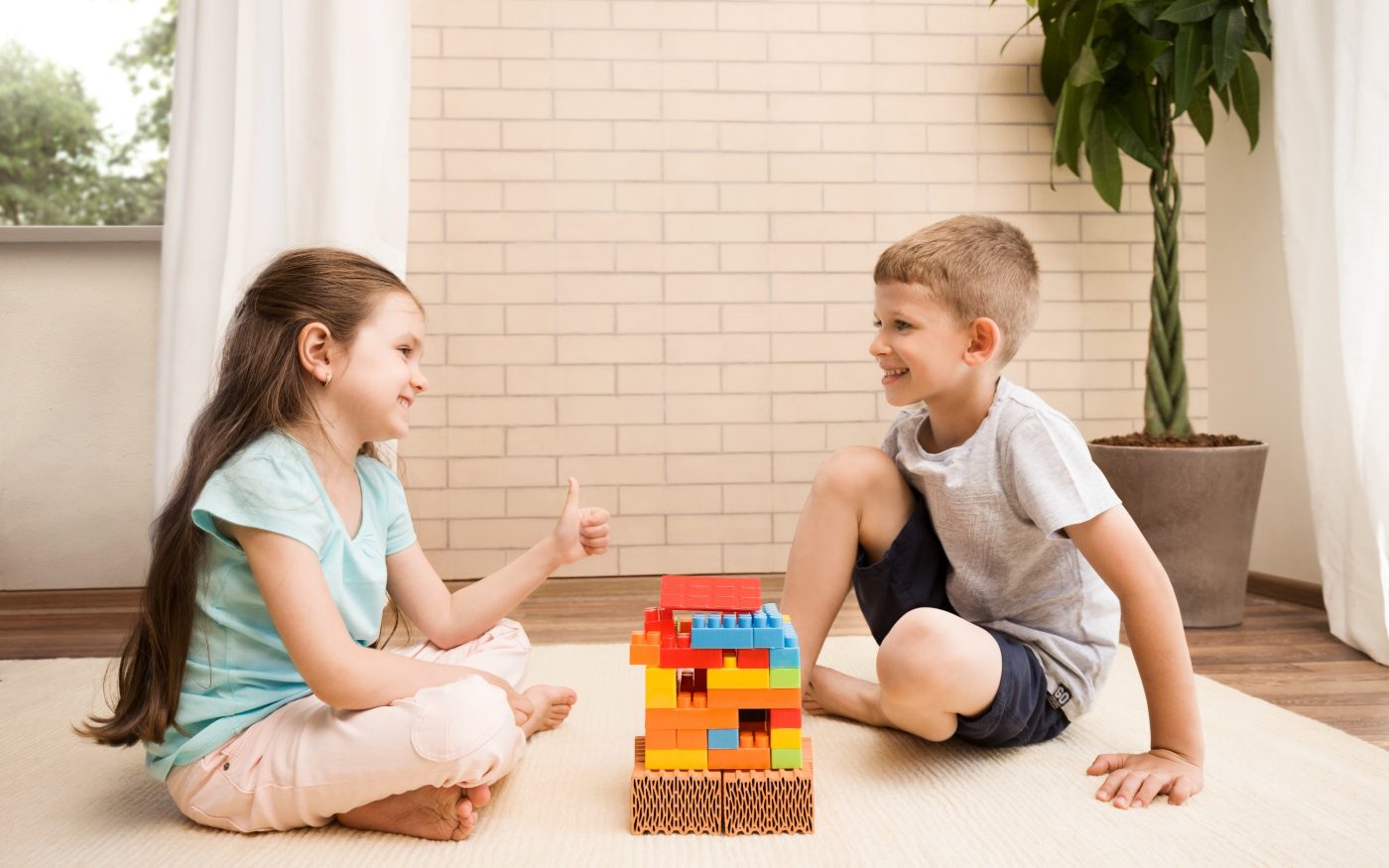 Children playing with miniature bricks and plastic building blocks