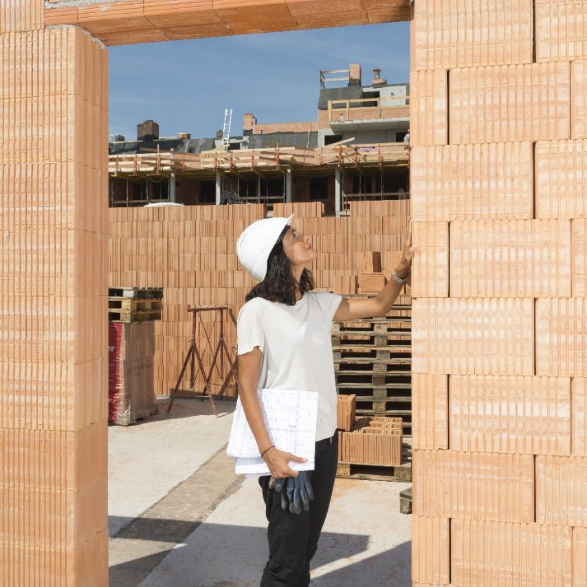 Female architect checking door frame on construction site